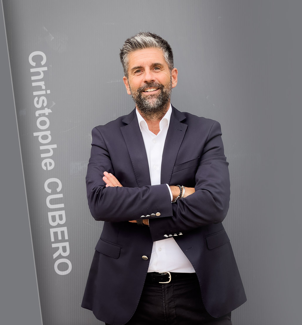 Christophe CUBERO, expert investissement immobilier Denormandie, Monuments Historiques, souriant, les bras croisés et portant une veste foncée, chemise blanche